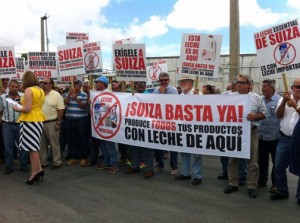 A reporter interviews Farm Bureau President Ramón González, as protesters set up in front of Suiza Dairy's headquarters.