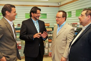 Vita Natura President Frank Medina (center) chats with executives who joined him for the Roosevelt Avenue store opening Tuesday.