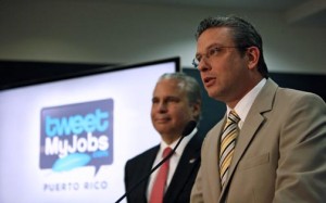 Gov. Alejandro García-Padilla discusses the details of the TweetMyJobs platform as Economic Development and Commerce Secretary Alberto Bacó stands by.