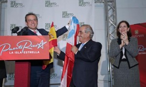 Gov. García-Padilla trades flags with Juan José-Hidalgo, president of Spanish airliner Air Europa, as Puerto Rico Tourism Co. Executive Director Ingrid Rivera looks on.