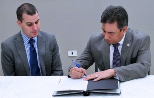 Edward Calvesbert Juliá, president of the board of directors of ABRE Puerto Rico and Manuel A. Torres Nieves, Electoral Comptroller, sign the agreement.