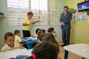 María E. Guzmán-Millán, pre-kindergarden teacher leads her group of students, as Félix Lugo, country manager of Columbus Business solutions, looks on.