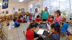 Olga Rodríguez (right), a tutoring mother, is observed by Mildred Melecio, administrative assistant for Juan Domingo en Acción and Catherine Ríos, community reinvestment officer at FirstBank.
