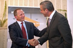 John Schmidt, global lead for Accenture's Aerospace & Defense practice shakes hands with Puerto Rico Gov. Alejandro García-Padilla during Wednesday's announcement.